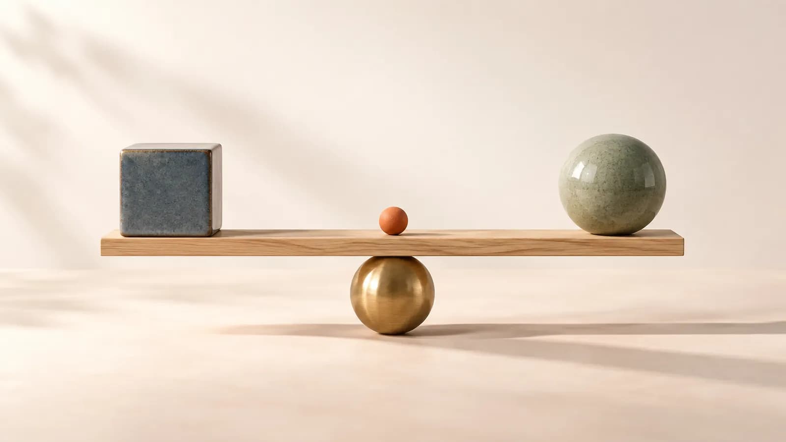 A level oak balance with a blue ceramic cube on one end and a sage sphere on the other